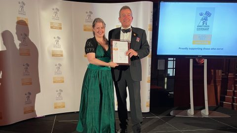 Keith White and Laura Shapland holding ERS Gold Award on stage